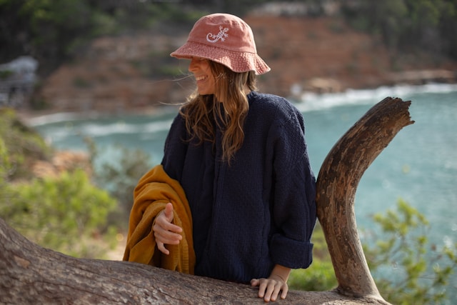 A woman in a pink hat sitting on a tree branch A woman in a pink hat sitting on a tree branch